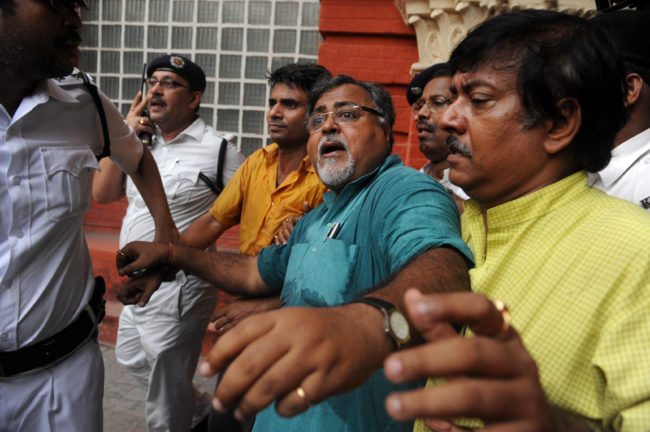 India's Trinamool Congress Party leader Partha Chatterjee (C) reacts as he is escorted out of the Writers Building, the state administrative headquarters, after arrested by police in Kolkata on October 16, 2009. Chatterjee, who is the opposition leader in the West Bengal state assembly, staged a demonstration in front Chief Minister Buddhadev Bhaterjee's office demanding the chief minister's arrest for the alleged arrest of innocent people. AFP PHOTO/Deshakalyan CHOWDHURY (Photo credit should read DESHAKALYAN CHOWDHURY/AFP/Getty Images)