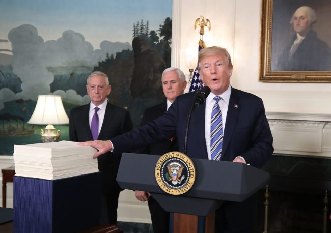 WASHINGTON, DC - MARCH 23: U.S. President Donald Trump gestures to the $1.3 trillion spending bill passed by Congress early Friday, with Vice President Mike Pence (C), and Defense Secretary Jim Mattis (L), in the Diplomatic Room of the White House on March 23, 2018 in Washington, DC. After threatening to veto the legislation earlier today, President Trump announced he had signed the bill, avoiding a government shutdown. (Photo by Mark Wilson/Getty Images)