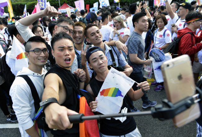 Supporters of same-sex rights take selfies during a gay pride parade in Taipei on October 28, 2017. Downtown Taipei was a sea of rainbow flags and glitzy costumes on October 28 as tens of thousands marched in Asia's largest gay pride parade, the first since Taiwan's top court ruled in favour of gay marriage. / AFP PHOTO / SAM YEH (Photo credit should read SAM YEH/AFP/Getty Images)