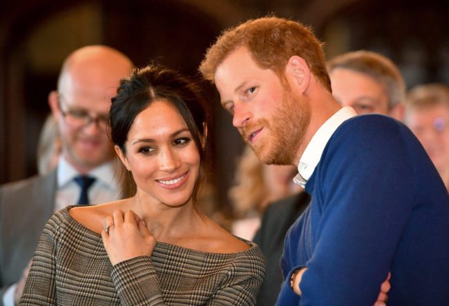 Prince Harry whispers to Meghan Markle as they watch a dance performance by Jukebox Collective in the banqueting hall during a visit to Cardiff Castle on January 18, 2018 in Cardiff, Wales. (Photo by Ben Birchall - WPA Pool / Getty Images)