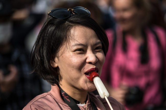 KAWASAKI, JAPAN - APRIL 01: (EDITORS NOTE: Image contains suggestive content.) A woman eats a phallic-shaped lollipop during Kanamara Matsuri (Festival of the Steel Phallus) on April 1, 2018 in Kawasaki, Japan. The Kanamara Festival is held annually on the first Sunday of April. The penis is the central theme of the festival, focused at the local penis-venerating shrine which was once frequented by prostitutes who came to pray for business prosperity and protection against sexually transmitted diseases. Today the festival has become a popular tourist attraction and is used to raise money for HIV awareness and research. (Photo by Carl Court/Getty Images)