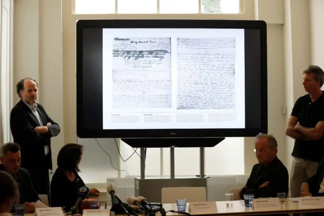 Ronald Leopold (L), executive director of the Anne Frank House, presents two unknown pages of Anne Frank's diary, during a press conference on May 15, 2018 in Amsterdam. - Two pages of Anne Frank's world-famous diary - which she covered over with brown paper, discovering dirty jokes and a teenager's interest in sex - have been made visible with digital photo-editing techniques. (Photo by Bas CZERWINSKI / ANP / AFP) / Netherlands OUT        (Photo credit should read BAS CZERWINSKI/AFP/Getty Images)