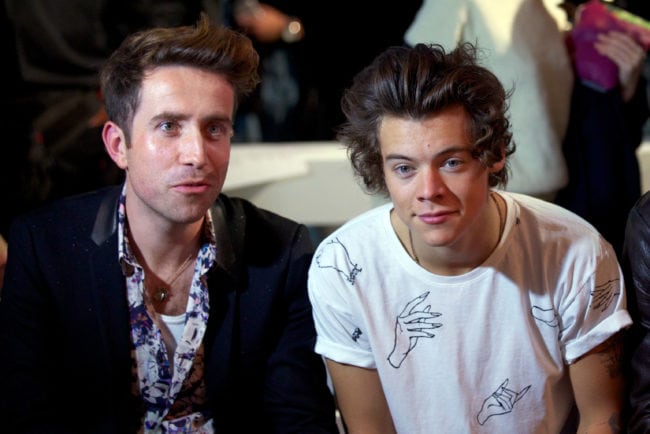 Singer Harry Styles of British band "One Direction" (R) and British TV and radio presenter Nick Grimshaw attend the Fashion East runway show during the 2014 Spring/Summer London Fashion Week in London on September 17, 2013. AFP PHOTO / ANDREW COWIE (Photo credit should read ANDREW COWIE/AFP/Getty Images)