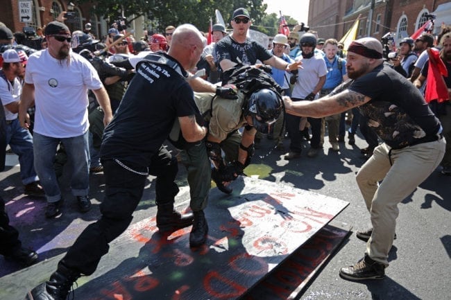 CHARLOTTESVILLE, VA - AUGUST 12:  White nationalists, neo-Nazis, the KKK and members of the "alt-right" attack each other as a counter protester (R) intervenes during the melee outside Emancipation Park during the Unite the Right rally August 12, 2017 in Charlottesville, Virginia. After clashes with anti-fascist protesters and police the rally was declared an unlawful gathering and people were forced out of Lee Park, where a statue of Confederate General Robert E. Lee is slated to be removed.  (Photo by Chip Somodevilla/Getty Images)