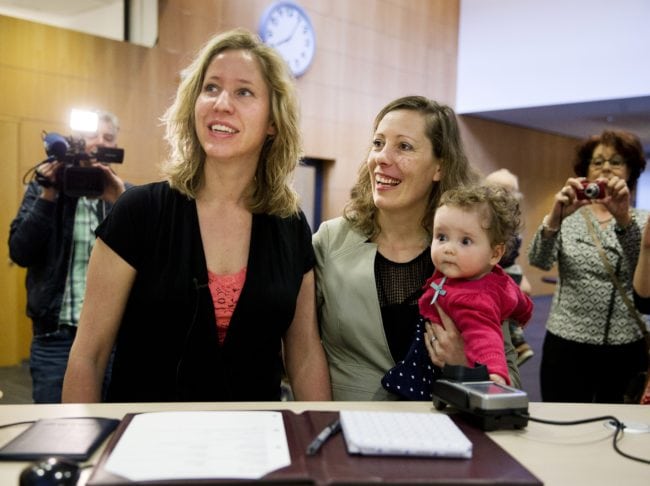 Corine (L) and Audrey Schep sign, along with their child Dieuwke, the first certificate of approvalthe first certificate of approval for a co-mother at the Zwolle city hall, The Netherlands, on April 1, 2014. Lesbian couples are now able to be both legal parents of a child of one of them, without going through complicated and costly procedures. AFP PHOTO / ANP - JERRY LAMPEN = netherlands out        (Photo credit should read JERRY LAMPEN/AFP/Getty Images)