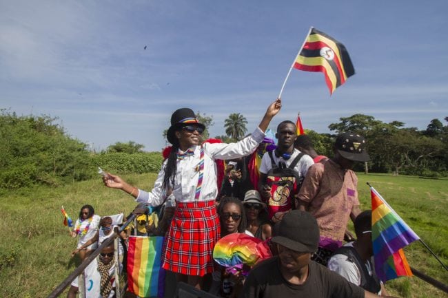 People waving Ugandan and rainbow flags take part in the Gay Pride parade in Entebbe on August 8, 2015. Ugandan activists gathered for a gay pride rally, celebrating one year since the overturning of a strict anti-homosexuality law but fearing more tough legislation may be on its way. Homosexuality remains illegal in Uganda, punishable by a jail sentence. AFP PHOTO/ ISAAC KASAMANI        (Photo credit should read ISAAC KASAMANI/AFP/Getty Images)