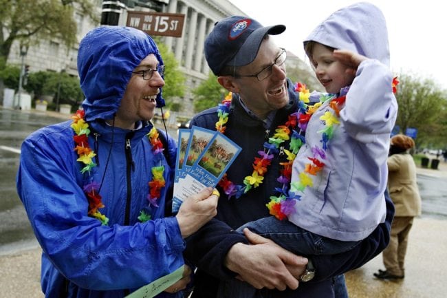 WASHINGTON - APRIL 17:  Doug Metcalfe (L) and his partner Brian Lahmann show their White House Easter Egg Roll event tickets to their daughter, Helen Lahmann-Metcalfe, 4, after picking up the tickets April 17, 2006 in Washington, DC. Members and supporters of Family Pride, a gay and lesbian parents' organization, wore rainbow-colored leis while attending to the 128-year-old event.  (Photo by Chip Somodevilla/Getty Images)
