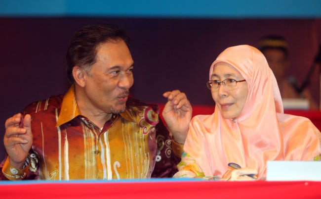 Malaysian opposition leader and former deputy prime minister Anwar Ibrahim (L) and his wife Wan Azizah Wan Ismail (R) President of People's Justice Party, gestures during the People's Justice Party National Congress 2010 in Petaling Jaya, near Kuala Lumpur on November 28, 2010. Malaysian opposition leader Anwar Ibrahim urged his party to close ranks and gear up for national polls, after a bout of bitter party infighting which he admitted has damaged its image. AFP PHOTO/ KAMARUL AKHIR (Photo credit should read KAMARUL AKHIR/AFP/Getty Images)