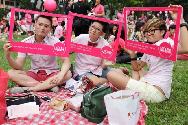 SINGAPORE - JUNE 30: Participants dress in various shades of pink, hold up placards during the 'Night Pink Dot' event arrange to increase awareness and understanding of the lesbian, gay, bisexual and transgender community in Singapore at Hong Lim Park on June 30, 2012 in Singapore. The event is the fourth annual gathering held in support of the freedom to love. (Photo by Suhaimi Abdullah/Getty Images)