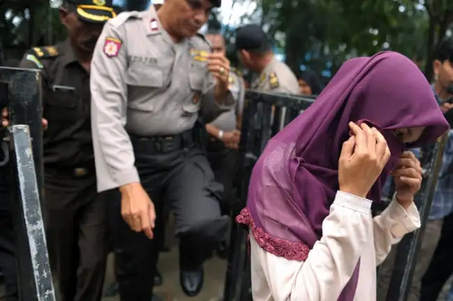 An Indonesian woman (R) walks prior to receiving 100 lashes of the cane for having sex outside marriage, which is against Sharia law, in Banda Aceh on November 28, 2016. Aceh is the only province in the world's most populous Muslim-majority country that imposes sharia law. People can face floggings for a range of offences -- from gambling, to drinking alcohol, to gay sex. / AFP / CHAIDEER MAHYUDDIN (Photo credit should read CHAIDEER MAHYUDDIN/AFP/Getty Images)