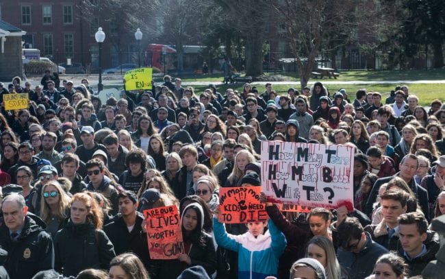 Students hold signs at Georgetown University in Washington, DC, on March 14, 2018 during a national walkout to protest gun violence, one month after the school shooting in Parkland, Florida, in which 17 people were killed. Students across the United States walked out of classes on Wednesday in a nationwide call for action against gun violence following the shooting deaths last month at a Florida high school. Hundreds of students from Washington area schools gathered outside the White House chanting "Never again!" and "Enough is enough!" and holding signs reading "Protect People Not Guns."  / AFP PHOTO / NICHOLAS KAMM        (Photo credit should read NICHOLAS KAMM/AFP/Getty Images)