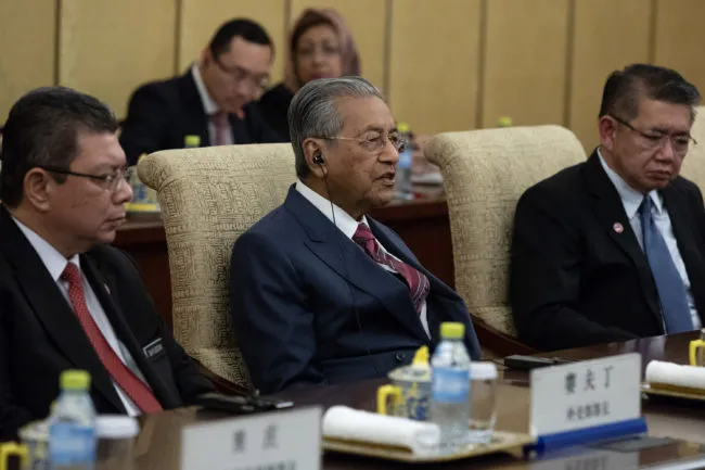 BEIJING, CHINA - AUGUST 20: Malaysian Prime Minister Mahathir Mohamad (C) speaks to Chinese President Xi Jinping (not pictured) during their meeting at Diaoyutai State Guesthouse on August 20 2018 in Beijing, China. (Photo by Roman Pilipey - Pool/Getty Images)