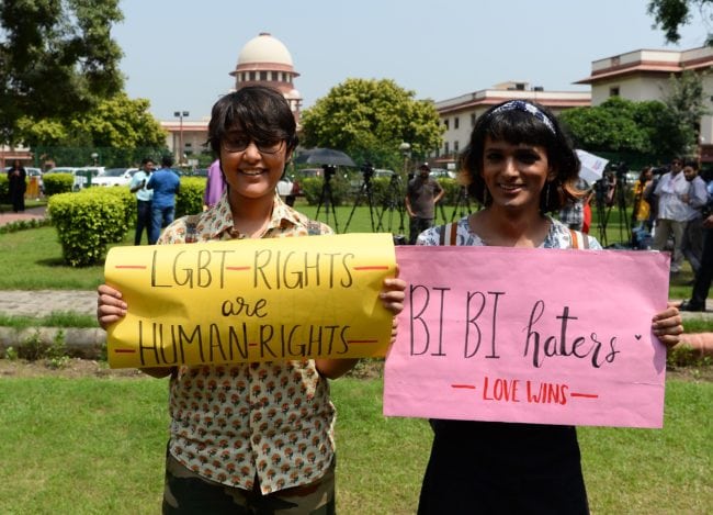 Indian members of the lesbian, gay, bisexual, transgender (LGBT) community hold placards outside the Supreme Court building as crowds gathered to celebrate the decision to strike down the colonial-era ban on gay sex in New Delhi on September 6, 2018. - India's Supreme Court on September 6 struck down the ban that has been at the centre of years of legal battles. "The law had become a weapon for harassment for the LGBT community," Chief Justice Dipak Misra said as he announced the landmark verdict. (Photo by Sajjad HUSSAIN / AFP) (Photo credit should read SAJJAD HUSSAIN/AFP/Getty Images)