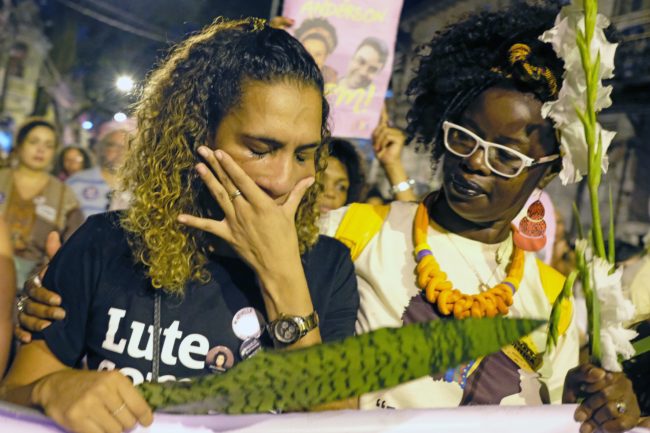 Anielle Silva (L), sister of activist Marielle Franco, cries at a memorial in Rio de Janeiro on April 14, 2018, one month after her murder in Lapa. The murder of Franco, a black Brazilian activist who fought her way out of the slums to become a popular councilor, made headlines around the world. The outspoken 38-year-old, who was a critic of police brutality, an advocate for minorities and the posterchild of a new type of politics, was shot dead on March 14 in an assassination-style killing with four bullets to the head.   / AFP PHOTO / DIEGO HERCULANO        (Photo credit should read DIEGO HERCULANO/AFP/Getty Images)