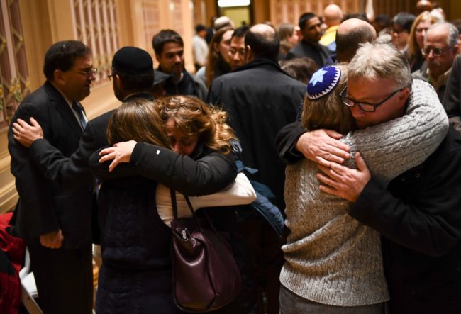 People hug after a vigil, to remember the victims of the shooting at the Tree of Life synagogue the day before, at the Allegheny County Soldiers Memorial on October 28, 2018, in Pittsburgh, Pennsylvania. - A man suspected of bursting into a Pittsburgh synagogue during a baby-naming ceremony and gunning down 11 people has been charged with murder, in the deadliest anti-Semitic attack in recent US history. The suspect -- identified as a 46-year-old Robert Bowers -- reportedly yelled "All Jews must die" as he sprayed bullets into the Tree of Life synagogue during Sabbath services on Saturday before exchanging fire with police, in an attack that also wounded six people. (Photo by Brendan Smialowski / AFP) (Photo credit should read BRENDAN SMIALOWSKI/AFP/Getty Images)