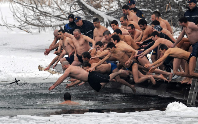 Bulgarians dive into icy water as they compete to catch a cross in the middle of a lake in Sofia on Epiphany Day on January 6, 2009. It is believed that the man who is the first to grab the cross, thrown into the water by an Eastern Orthodox priest, will be healthy throughout the new year.   AFP PHOTO / DIMITAR DILKOFF (Photo credit should read DIMITAR DILKOFF/AFP/Getty Images)
