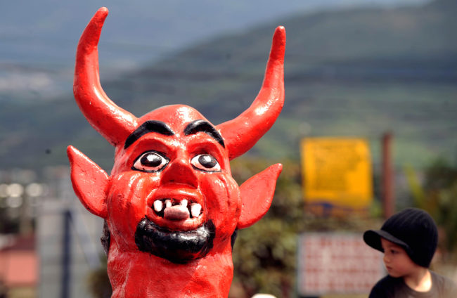 A photo of a man in a devil mask