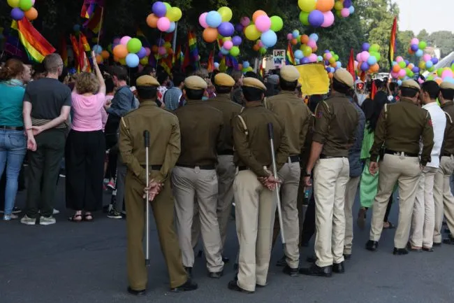 Police keep watch as Indian members and supporters of the LGBT community march