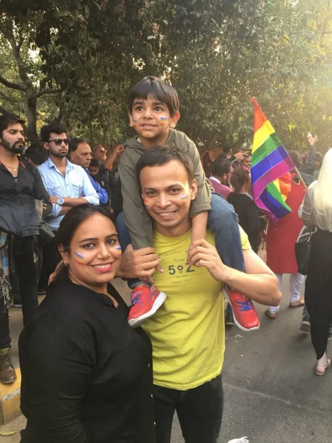 Man, woman and child pose for a photo at the first Indian Pride parade since the decriminalisation of gay sex