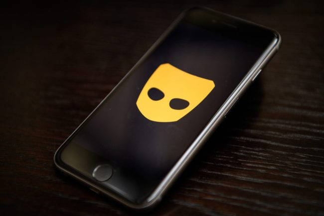 A phone displays the logo of gay hook-up app Grindr