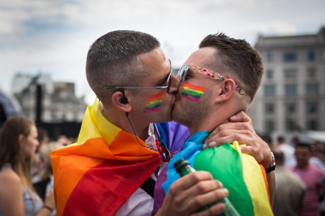 A gay couple kiss in Trafalgar Square after the annual Pride in London Parade