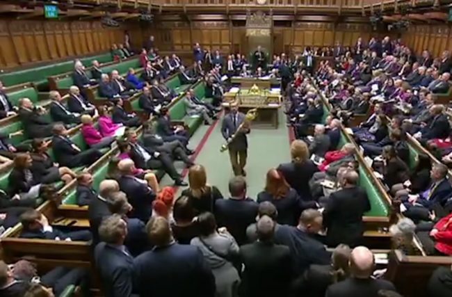 Lloyd Russell-Moyle takes the ceremonial mace from its table and holds it in protest