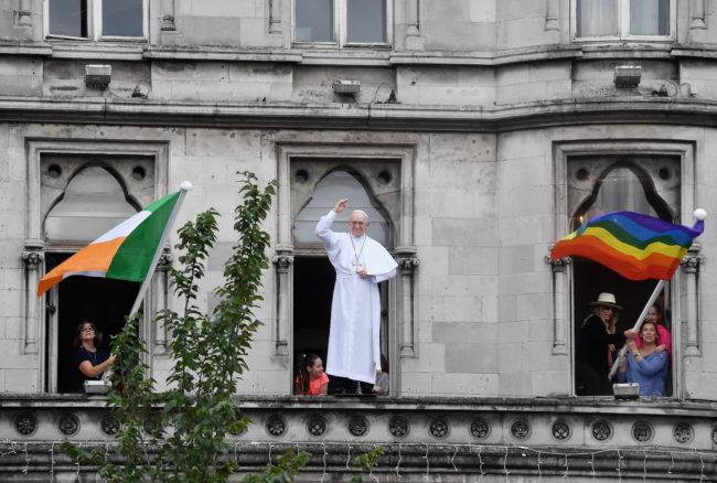 The Irish flag and a rainbow flag are placed on each side of a model of Pope Francis during his visit to Ireland.