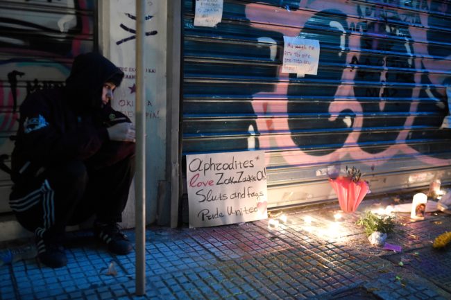 A girl sits by a makeshift memorial outside a jewellery shop where Zak Kostopoulos, a Greek militant homosexual was lynched on September 21.