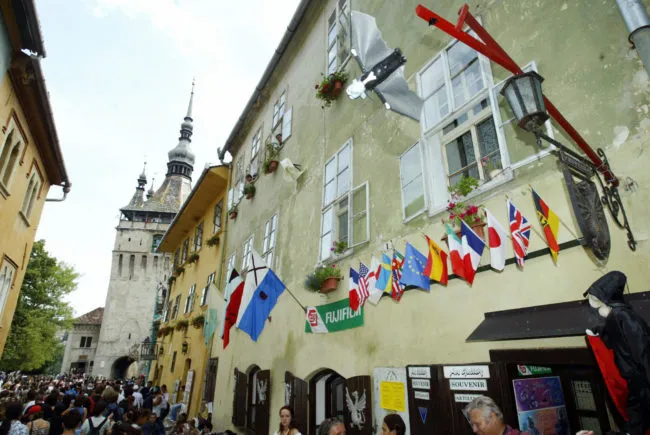 A Dracula-like puppet flight over the people in front of a souvenirs store in Sighisoara, where the viral gay love story is set.
