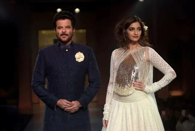 Indian Bollywood actors Anil Kapoor and daughter Sonam Kapoor model creations by designer Manish Malhotra during a charity fashion show in Mumbai on April 4, 2015