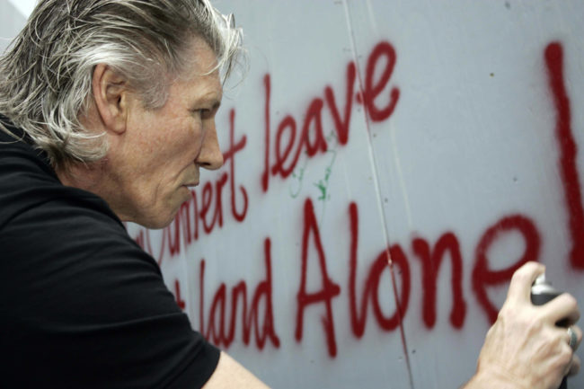 British rock legend Roger Waters, one of the signatories of a letter demanding the BBC opposed Israel hosting Eurovision, spraypaints a graffiti against Israel?s separation barrier surrounding the West Bank town of Bethlehem.