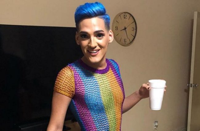 A Facebook photo of Kevin Fret holding a cup and wearing a rainbow outfit