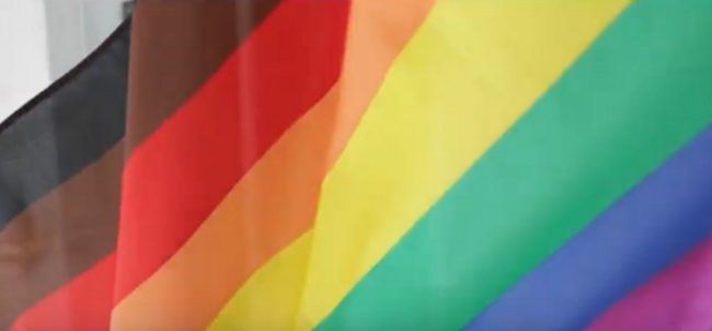 Drag queen backlash: A still of Manchester Pride's promotional video, featuring an eight-striped Pride flag