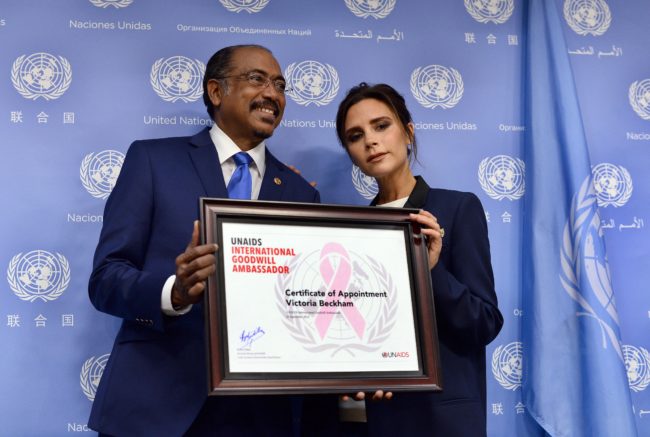 Executive Director of Joint UN Programme on HIV/AIDS Michel Sidibe (L) presents British fashion designer Victoria Beckham with a UNAIDS international goodwill ambassador certificate during a press conference on the sideline of the 69th Session of the UN General Assembly at the United Nations in New York on September 