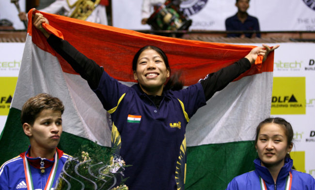 Indian boxer MC Mary Kom (C) is watched by silver medalist Steluta Duta (L) of Romania and bronze medalist Jong OK (R) of North Korea as she celebrates during prize ceremony, after winning a gold medal at the fourth World Women's Boxing Championship in New Delhi, 23 November 2006. India won four gold medals at the Championships which took place in the Indian capital from 18-23 November. 