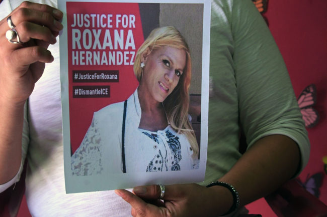 A member of the Pink Unity Collective holds a photo of Roxana Hernandez. 