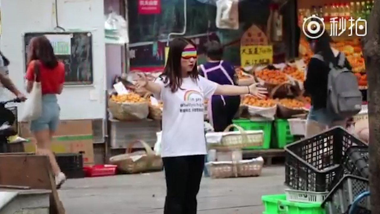 Woman protesting for LGBT+ rights to tackle Weibo's censoring of LGBT+ content.