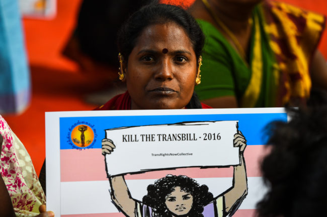 A woman holding a placard reading "kill the transbill"