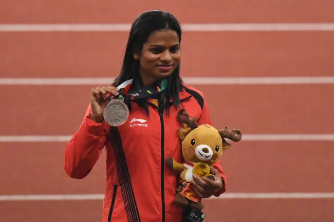 Silver medallist India's Dutee Chand celebrates during the victory ceremony for the women's 200m athletics event during the 2018 Asian Games in Jakarta. (ANTHONY WALLACE/AFP/Getty Images)