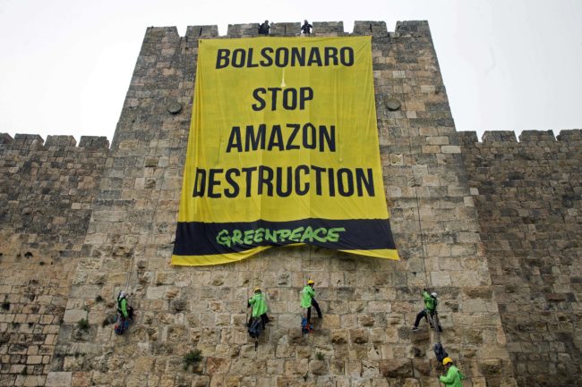 Greenpeace activists hang a large banner on the ramparts of the Old City of Jerusalem with a message to the visiting Brazilian president concerning the Amazon, on April 1, 2019.