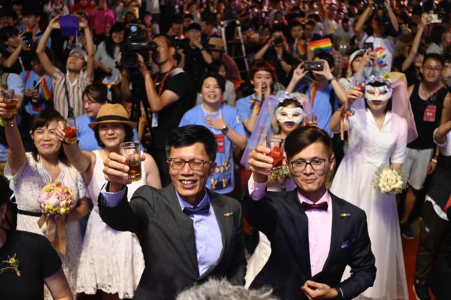 China Taiwan response: A gay couple gesture during a mass wedding banquet in front of the Presidential Palace in Taipei on May 25, 2019.
