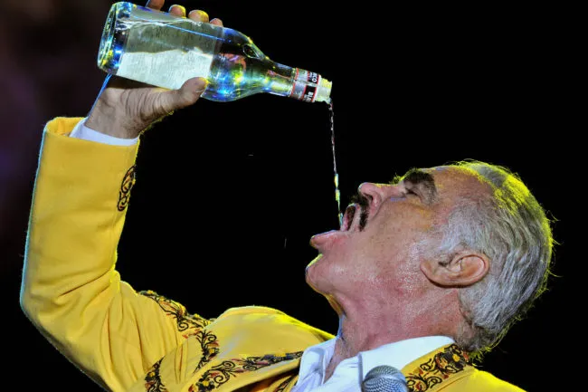 Mexican singer Vicente Fernandez drinks aguardiente during his concert on February 20, 2009 in Colombia.