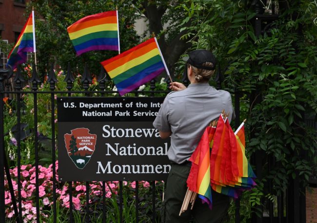 National Park Service rangers places rainbow flags on the fence at the Stonewall National Monument in the West Village neighborhood of Greenwich Village in Lower Manhattan, New York City on June 19, 2019. 